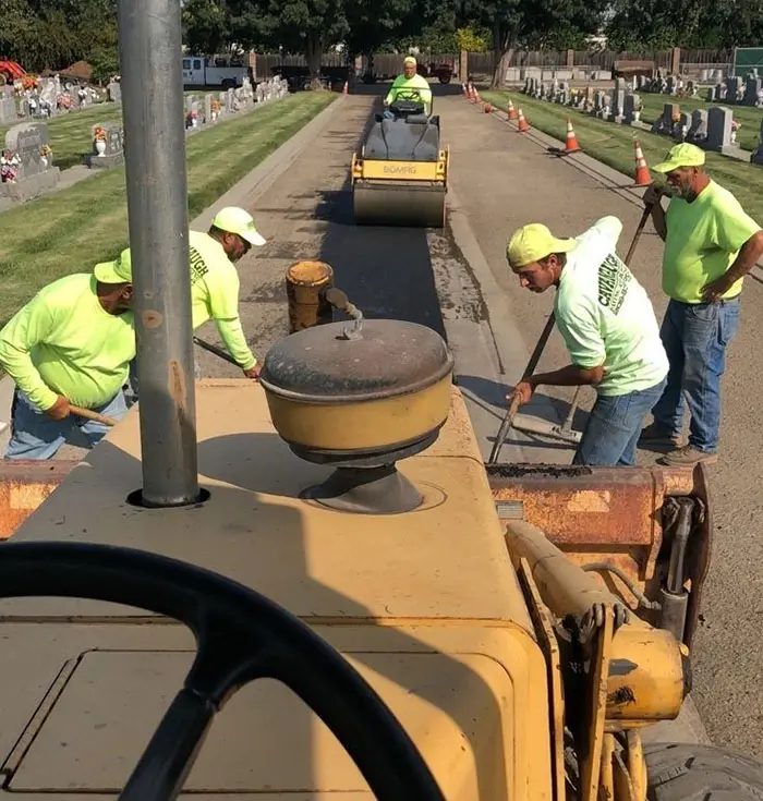 A group of men working on the side of a road.